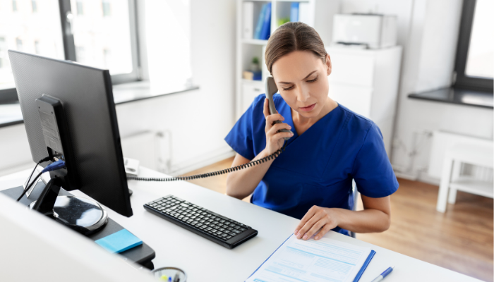 Woman working by a desk and speaking in the telephone 
