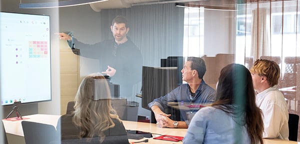 fem personer som sitter i ett konferensrum och jobbar på Centuri