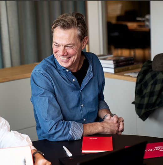 bild på Centuris VD i blå skjorta som sitter leende i ett möte